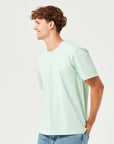 Mann trägt ein mint grünes BoxFit T-Shirt aus 100% Bio-Baumwolle – nachhaltige Herrenmode, lässiger Oversize-Schnitt, umweltfreundlich & bequem