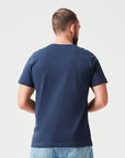 Mann trägt Navy Premium T-Shirt aus 280 GSM Bio-Baumwolle. Hochwertiges, umweltfreundliches Basic-Shirt mit Rundhalsausschnitt, ideal für lässige Alltagsoutfits.